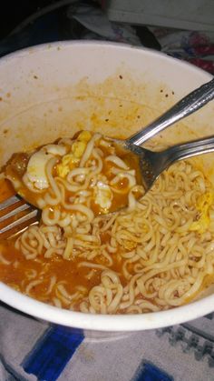 a white bowl filled with noodles and meat