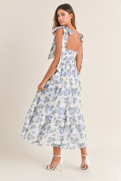 Elegant, trendy, and chic, our Florence Blue Floral Tie Strap Midi Dress is perfect for wedding guests, special events, showers, and vacations abroad. Featuring a ruched bodice, tie straps, tiered skirt, padded inserts, a smocked back, back zipper closure, and a blue floral print pattern throughout. Lined. 100% Polyester. True to size. Model measurements: Height 5'5", Bust 33", Waist 25", Hips 33" wearing a size Small. Cindy Dress, Flower Maxi Dress, Floral Bustier, Bra Cup, Tiered Midi Dress, Flowing Skirt, Dresses By Length, Dress With Tie, Crop Top Sweater