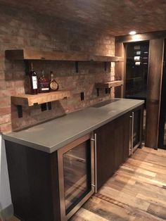 a kitchen with brick walls and stainless steel counter tops, built - in wine cellar