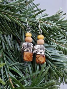 "Engraved silver elephant beads serve as the feature beads on these 1\" long handmade dangle earrings. Elephants are paired with brown Czech glass squares, wood rounds, and mustard speckled Czech glass nuggets. Stacked earrings hang on silver fishhook ear wires to a total drop length of 1.5\". All of ABEADZA's handmade creations are ready to ship next day via the US Postal Service. Thank you for shopping with us!" Handmade Dangle Earrings, Silver Elephant, Stacked Earrings, Earrings Handmade Dangle, Silver Elephants, Silver Engraving, Wood Rounds, Wood Earrings, Etsy Earrings Dangle