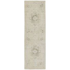 a white rug with an intricate design on the front and back side, in grey tones