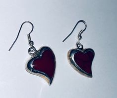 "This is a pair of heart-shaped sterling silver (.925) red dangle/drop earrings. Material(s): Sterling Silver (.925) + red stone (the photos make the heart appear black, but they are a dark red) Total weight: 6.2 grams Flaws (if any): None to mention Marking(s): \".925\" (translating to \"sterling silver\") Measurements: The drop length of these earrings is 1 and 3/8 inches. The width of these earrings is 3/4 of an inch, at their widest point. If you have any questions about this pair of earring Vintage Red Heart Earrings For Pierced Ears, Red Vintage Heart Earrings, Red Sterling Silver Dangle Heart Earrings, Red Sterling Silver Pierced Heart Earrings, Vintage Red Sterling Silver Earrings, Vintage Red Heart Earrings For Gift, Red Vintage Sterling Silver Earrings, Red Vintage Heart Earrings For Gifting, Vintage Red Heart Earrings As Gift