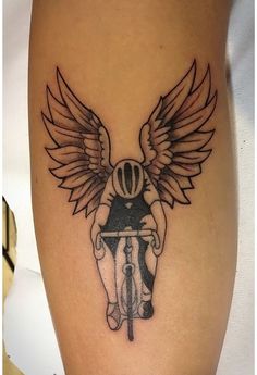 a tattoo with an angel riding a bike on it's thigh and wings above the knee