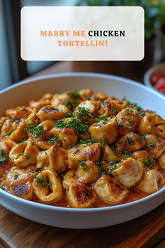 a white bowl filled with tortellini on top of a wooden table