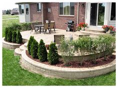 an outdoor patio and landscaping area in front of a house