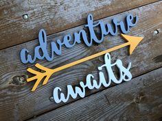 a wooden sign that says adventure awaits with an arrow