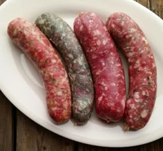 four different types of sausage on a white plate