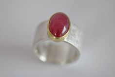 925 sterling silver with a beautiful shining ruby, set in 750 gold, partly polished, Dimensions of the ring band: approx. 10.4 mm wide, 1.7 mm thick Stone size: 13 x 9 mm Ruby shows natural inclusions Weight 14.6g size 55.5 - 56 / 17.7 / 7.75 Expandable up to size 57 Unique sterling silver ring "Blickfang 42" by Frank Schwope Unique jewellery, Ruby, Gold, Ring, Goldsmith work, Unique jewellery, Noble, Ruby red, Red, Unique Jewellery Handmade Ruby Ring, Handmade Unique Ruby Ring, Unique Ruby Ring With Polished Finish, Unique Ruby Ring With Polished Sterling Silver, Handmade Silver Ruby Ring, Hand Forged Ruby Ring In Red, Hand Forged Red Ruby Ring, Handmade Ruby Ring In Yellow Gold, Modern Red Ruby Ring In Sterling Silver