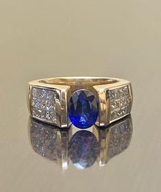 a blue and white diamond ring sitting on top of a table