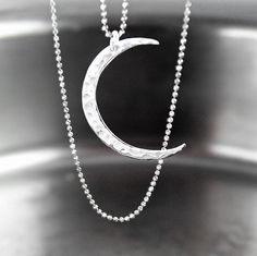 Dainty pendant necklace featuring lightweight shiny .925 Sterling silver hammered crescent moon pendant suspended from sparkly, diamond cut .925 Sterling silver chain. Delicate and subtle by itself, but also makes a great layering necklace.  More details : - High quality USA or Italian made chain and components - ALL .925 Sterling Silver - very sparkly tiny (1mm) diamond-cut bead chain, crescent moon pendant (30x22mm), wire, and trigger clasp. - Choose the length of the necklace from the drop down menu options.  -- More CELESTIAL jewelry, in my shop: https://www.etsy.com/shop/DorotaJewelry?ref=seller-platform-mcnav&search_query=celestial --- All of the designs in my shop are handmade by me in my Virginia studio. Elegant GIFT BOX is included with your order YOU CAN ENTER MY SHOP HERE: http: Luxury Silver Moon-shaped Necklace, Pjo Oc, Sterling Silver Layered Necklace, Crescent Moon Necklace Silver, Dainty Pendant Necklace, Crescent Moon Pendant, Dainty Pendant, Crescent Moon Necklace, Celestial Jewelry