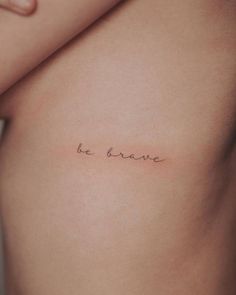 a woman's stomach with the word be brave written on it, in cursive font