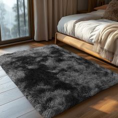 a bed room with a neatly made bed and a large rug on the wooden floor