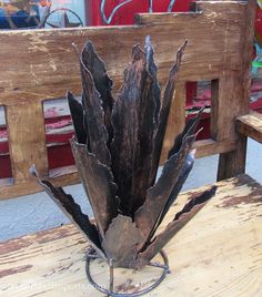 a wooden bench with a metal planter on it