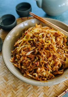 a bowl filled with noodles and chopsticks on top of a table