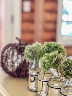 small glass vases with flowers in them on a counter