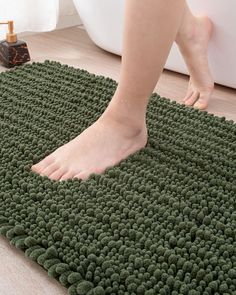 a person walking across a bathroom rug on the floor