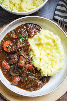 two bowls filled with stew and mashed potatoes