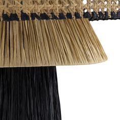 a lamp that is made out of straw and has a black shade on the top