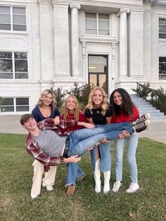 a group of young people posing in front of a building