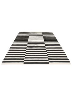 a black and white striped rug on top of a white floor with an area rug in the middle