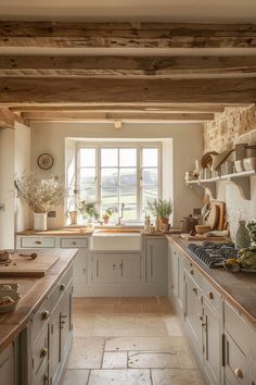 a kitchen filled with lots of counter top space and wooden beams above the sink area