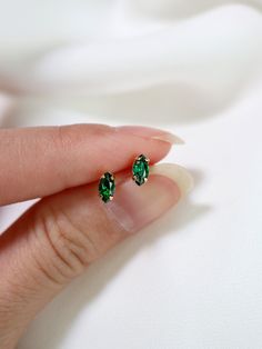 "Tiny marquis stud earrings in a lush dark green, also the birthstone for the month of May. Hand set faceted pinched oval cubic zirconia subtly catch the light. Hardware has been tumble polished for hours to achieve a satin finish, butterfly backings. Packaged in a beautiful gift box. Perfect for standard lobe piercings and make great stacking pieces for 2nd and 3rd piercings (shown worn in the last photo, paired with our micro star studs https://www.etsy.com/listing/706430537/ ). MATERIALS [ st 3rd Piercings, Lobe Piercings, Minimalist Earring, May Birthday, Month Of May, Tiny Earrings, Star Studs, Beautiful Gift Boxes, Minimalist Earrings