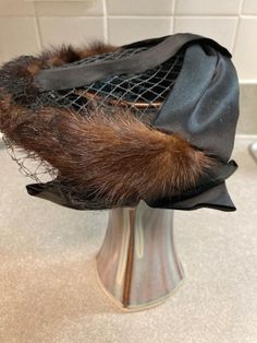 What a fabulous dressy stylish vintage ladies hat!.  This hat features a net veil that can be worn over face or tucked inside the hat. Mink/sable fur ( not certain) with black satin trim. This small hat is intended to be worn sitting atop the head. Often worn a little forward with veil. This vintage hat is small. 6 inches across- slightly expands so the hat will fit snug when in place.  Please see the photos as part of the description. In very well cared for cherished condition. Net Veil, Dressy Hats, Vintage Hat, Sheffield, Hats Vintage, Black Satin, Hats For Women, Veil, 6 Inches