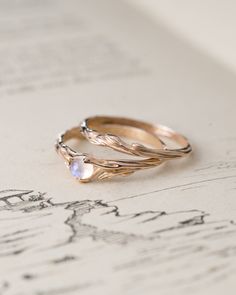 two gold rings sitting on top of an open book