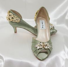 a pair of green high heeled shoes with jewel embellishments