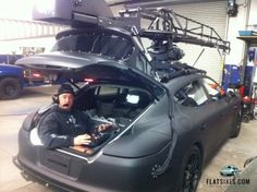 a man sitting inside of a car in a garage