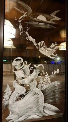 a glass window with an image of santa sleigh and reindeer in the sky