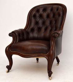 an old fashioned leather chair with wheels on it's legs and footrests