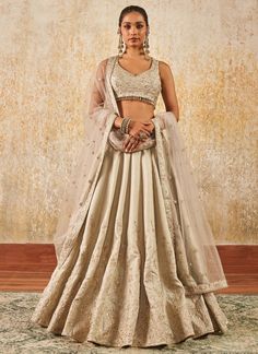 Our Light Grey Embroidered Lehenga includes a silk top with santoon inner, silk bottom with santoon inner, and a net dupatta. Embroidery is present on this style using zari, sequins, and thread work.  Like all of our pieces, this piece is made in India and checked by hand to ensure high quality. Navratri Embellished Silk Lehenga, Embellished Tissue Silk Lehenga For Festivals, Embellished Silk Lehenga For Navratri, Festive Embroidered Lehenga In Chinon, Embellished Fitted Raw Silk Lehenga, Embellished Silk Lehenga For Reception, Embellished Raw Silk Saree Set, Anarkali Silk Embellished Lehenga, Bollywood Style Embellished Tissue Silk Lehenga