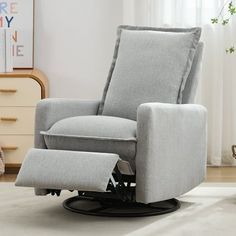 a grey recliner chair sitting on top of a white rug