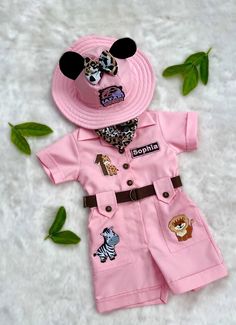 a pink hat and shirt with animal patches on it