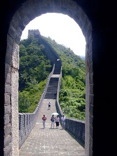 people are walking up and down the great wall, with an arch in the middle