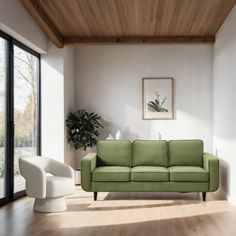 a living room with a green couch and two white chairs in front of large windows