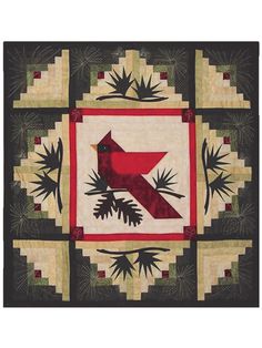 a red bird sitting on top of a green and white patchwork quilt with pine cones