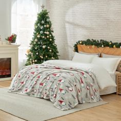 a bedroom decorated for christmas with a bed and fireplace