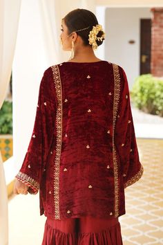 Maroon straight kurta with gold zardosi, aari and kundan embroidery. Paired with a gharara and dupatta.
Components: 3
Pattern: Embroidered
Type Of Work: Zardosi, Aari, Kundan
Neckline: U Neck
Sleeve Type: Flared
Fabric: Kurta: Silk Velvet, Gharara: Satin Silk, Dupatta: Organza
Color: Maroon
Other Details: 
Approx. product weight: 1.5 kg
Length:
Kurta: 33 inches
Gharara: 38 inches
Note: Outfit worn by the model on the right is not for sale.
Occasion: Mehendi and Haldi - Aza Fashions Festive Shantoon Palazzo Set With Resham Embroidery, Designer Dabka Sharara In Shantoon, Eid Sharara With Dabka Work In Nida Fabric, Eid Sharara With Dabka Work In Nida, Festive Shantoon Palazzo Set With Zari Work, Festive Nida Sharara With Dabka Work, Festive Anarkali Palazzo Set In Shantoon, Velvet Sharara For Navratri Festival, Eid Nida Sharara With Resham Embroidery