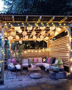 an outdoor patio with lights and furniture on the outside, surrounded by wood planks