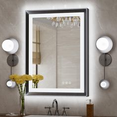 a bathroom sink sitting under a mirror next to a wall mounted faucet with lights on it