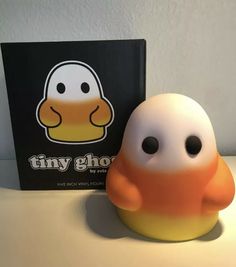 an orange and white toy sitting next to a book