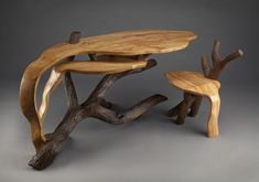 a wooden table and two stools made out of tree branches, on a gray background