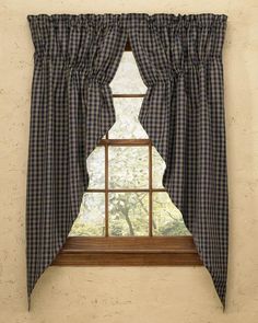 a window with a checkered curtain hanging on it's side and a tree in the background