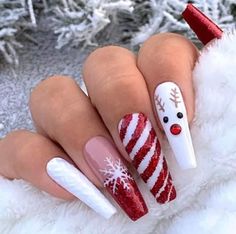 a person with red and white nail polish on their nails, holding a candy cane