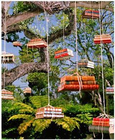 a tree filled with lots of books hanging from it's branches in the air