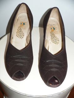 Pair of 1940's brown suede shoes with a peep toe. They have the Peacock Shoe label inside. They have decoration on the vamp of 3 cutouts with brown grosgrain material under with stitching and tiny metal studs. Inside is a 7 which I believe is the size.They are 9 1/4 inches long and 2 7/8 inches across widest part of sole. Heels are 2/12 inches. They are in very good vintage condition with a small piece out of the suede on the bottom of one heel. Vintage Open Toe Suede Heels, Peacock Shoes, Brown Suede Shoes, The Peacock, Peep Toe Shoes, Needle Lace, The Vamps, Toe Shoes, Suede Shoes