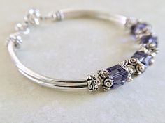 This comfortable bangle bracelet is so pretty in person. Perfect for your bridesmaids on your special wedding day! Can also be given for an anniversary, birthday or mothers day gift among many others... Choose from many colors from the dropdown menu at checkout. ~ 6mm tanzanite swarovski crystal cubes ~ pewter bead caps ~ silver plated tube bead bangles and toggle Click here to return to my shop's homepage: https://www.etsy.com/shop/beadedjewelryforyou?ref=simple-shop-header-name&listing_id= Adjustable Crystal Bracelet For Anniversary On Mother's Day, Personalized Adjustable Crystal Bracelet For Anniversary, Sterling Silver Birthstone Bracelets For Wedding, Adjustable Sterling Silver Crystal Bracelet For Anniversary, Silver Beaded Bracelets With Birthstone For Wedding, Adjustable Silver Crystal Bracelet With Birthstone, Adjustable Birthstone Beaded Bracelets For Anniversary, Adjustable Silver Birthstone Crystal Bracelet, Hypoallergenic Beaded Bracelets For Anniversary