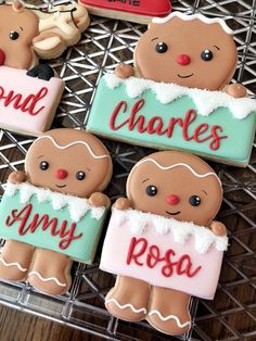 four decorated cookies sitting on top of a wire rack next to each other with name tags